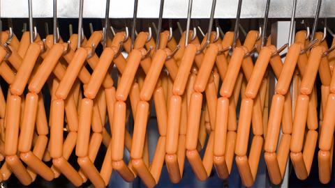 Les saucisses pendent sur le convoyeur