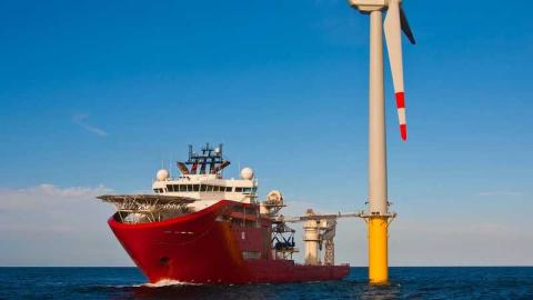 Ship next to offshore wind turbine