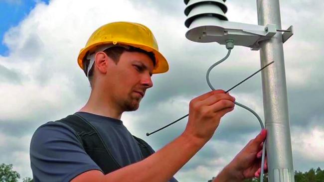 Engineer installing outdoor HVAC sensors