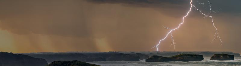 Landscape scenery with lightning over cliffs and sea